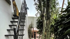 A staircase leading to a building with a white exterior wall and a metal railing. - Escape a la Ciudad en Nuestro Encantador Apartamento con Todas las Comodidades (San Rafael Arriba de Desamparados)