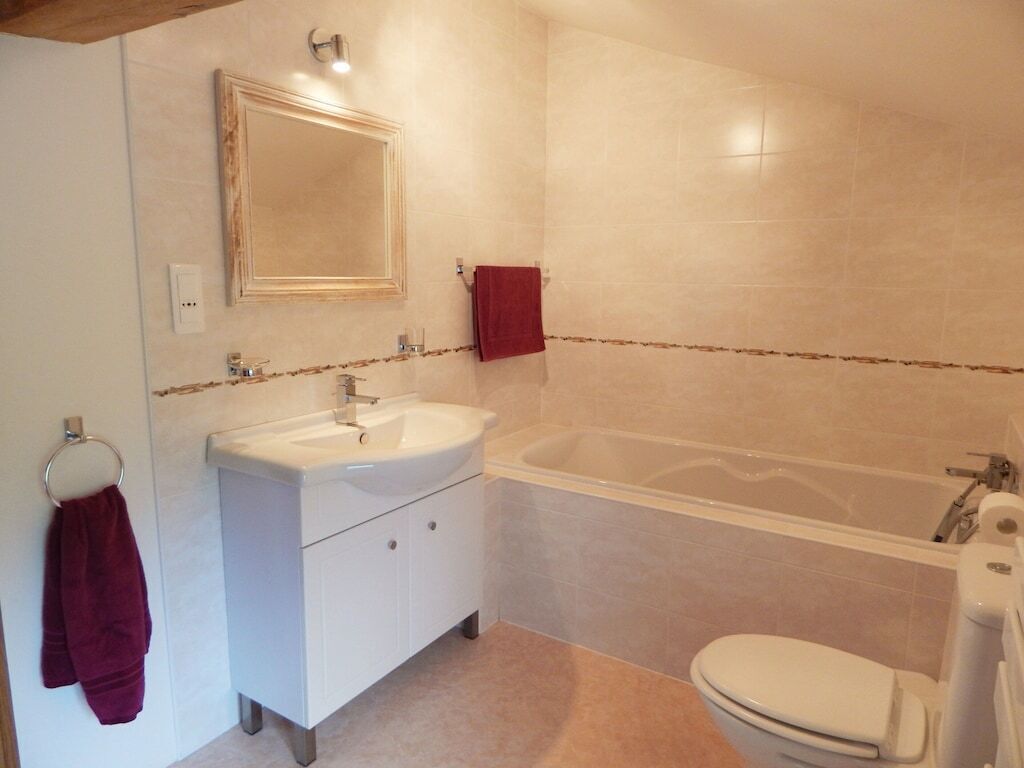 Une salle de bain avec un lavabo, un miroir et une baignoire.
