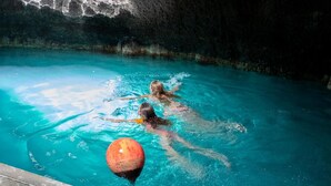 Une piscine avec une eau d’un bleu limpide et deux bouées orange.