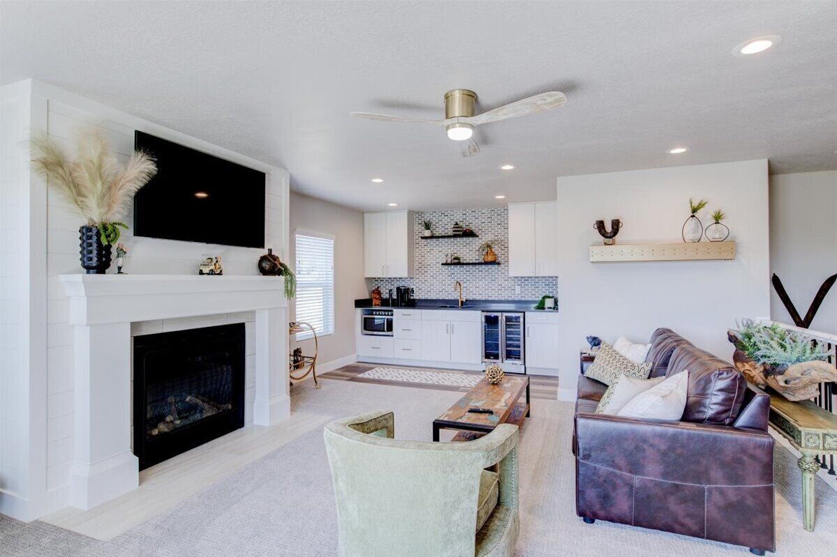 A modern living room with a fireplace, a television, and a dining area with a wooden table and chairs.
