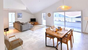 Un grand espace de vie comprenant une table à manger, un canapé et un téléviseur.