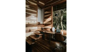 A wooden interior with a desk, chair, and a hanging pendant light.
