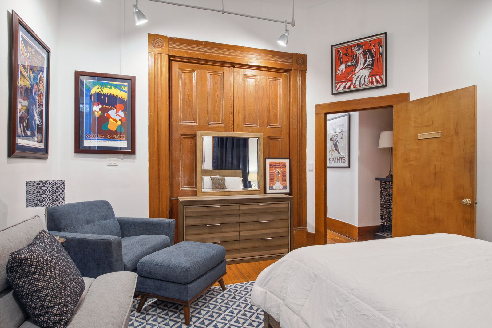 A bedroom with a bed, a dresser, a chair, and a wardrobe.