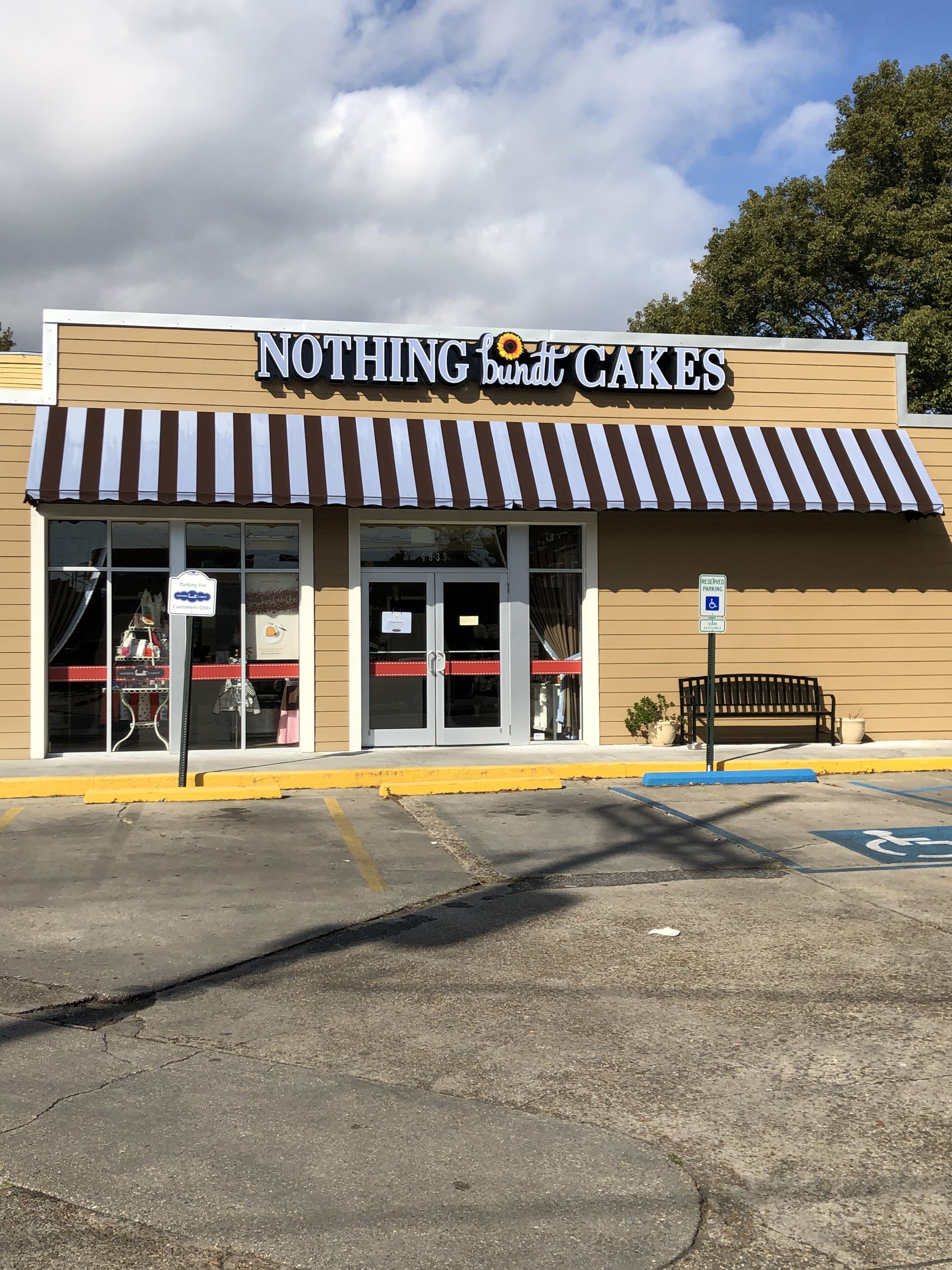 Un escaparate con un letrero que dice "Nothing but Cakes" y un cartel de estacionamiento reservado para personas con discapacidad.