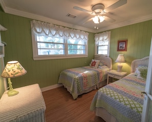 A room with two beds, a ceiling fan, and a window with curtains. - Historic 1940's Beach Cottage, steps to the beach! (Tybee Island)