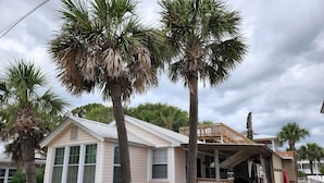 A small, single-story house with a porch and a covered deck area. - Historic 1940's Beach Cottage, steps to the beach!   (Tybee Island)