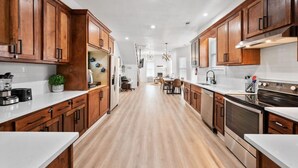 A modern kitchen with wooden cabinets, stainless steel appliances, and a central island.