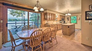 A spacious kitchen with wooden cabinets, a large island, and a dining area with a table and chairs. - Cozy Hayward Cottage w/ Dock & Lakefront View (Hayward)