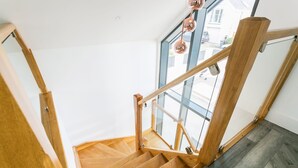 A wooden staircase with glass railings and a view of the outside. - Gwel y Wyddfa - sleeps 6 guests in 3 bedrooms (Rhosneigr)