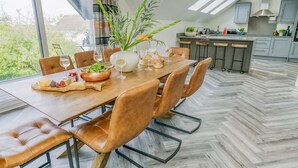 Un comedor moderno con una mesa de madera, sillas de cuero y vistas al exterior.