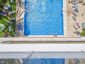 A rooftop pool with clear blue water, surrounded by lounge chairs and umbrellas. - Frontal beach view apartment with spacious balcony (Marbella)