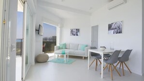 Un soggiorno moderno con un divano bianco, un tavolo da pranzo con sedie e opere d'arte alle pareti.