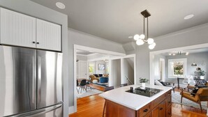 Una cocina moderna con un refrigerador de acero inoxidable, armarios de madera y una isla central con fregadero.