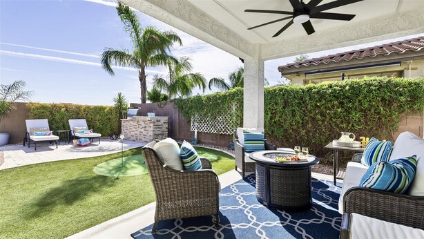 A covered patio with wicker furniture, a grill, and a small pool. - Great Neighborhood, Heated Pool &Spa, Putting Area! (Peoria)
