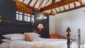 Ein Schlafzimmer mit Bett, Lampe, Fenster und Stuhl.