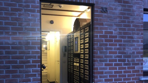 A brick building with a glass door entrance leading to a hallway. - Résidence la Fraisière Bxl the ideal place to stay in European C.. (Anderlecht)