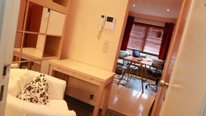 A room with a white sofa, a wooden desk, and a computer setup in the background. - Résidence la Fraisière Bxl the ideal place to stay in European C.. (Anderlecht)