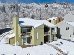 Ein zweistöckiges Gebäude mit Balkon, Garage und überdachter Auffahrt.