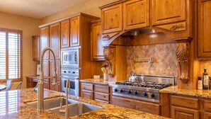 A kitchen with granite countertops, stainless steel appliances, wooden cabinets, and a large island with a sink. - Gilbert 4BR Villa|Heated Pool+Games|Sleeps 12 (Gilbert)