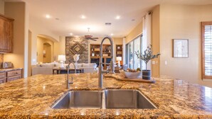 A kitchen with granite countertops, stainless steel sink, and a stone backsplash. - Gilbert 4BR Villa|Heated Pool+Games|Sleeps 12 (Gilbert)