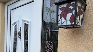 A white door with a brass handle and a glass panel with a floral design.