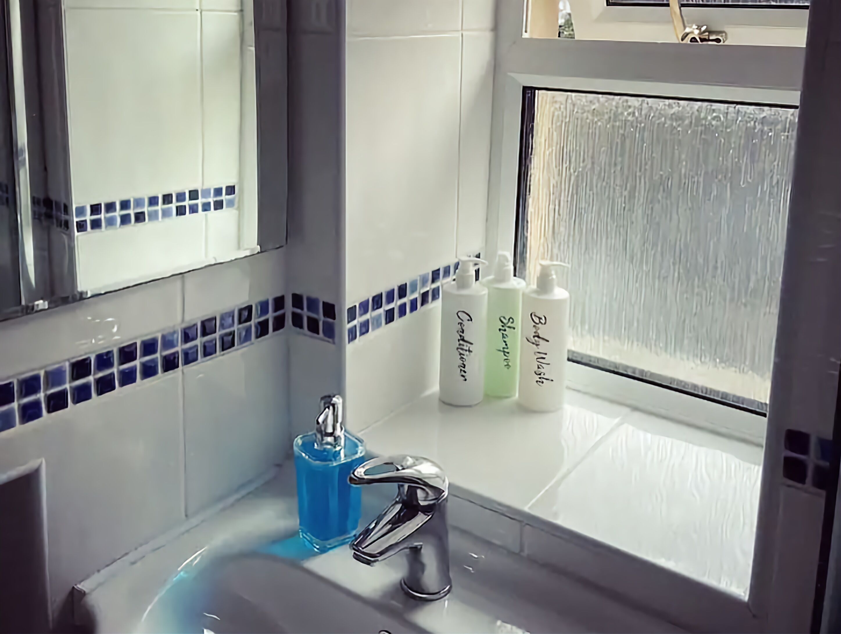 A bathroom with a sink, mirror, and toiletries.