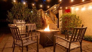 An outdoor patio with a grill, a fire pit, and wooden chairs. - Walk to UF Stadium! Fabulous Chic Historic Home (Gainesville)