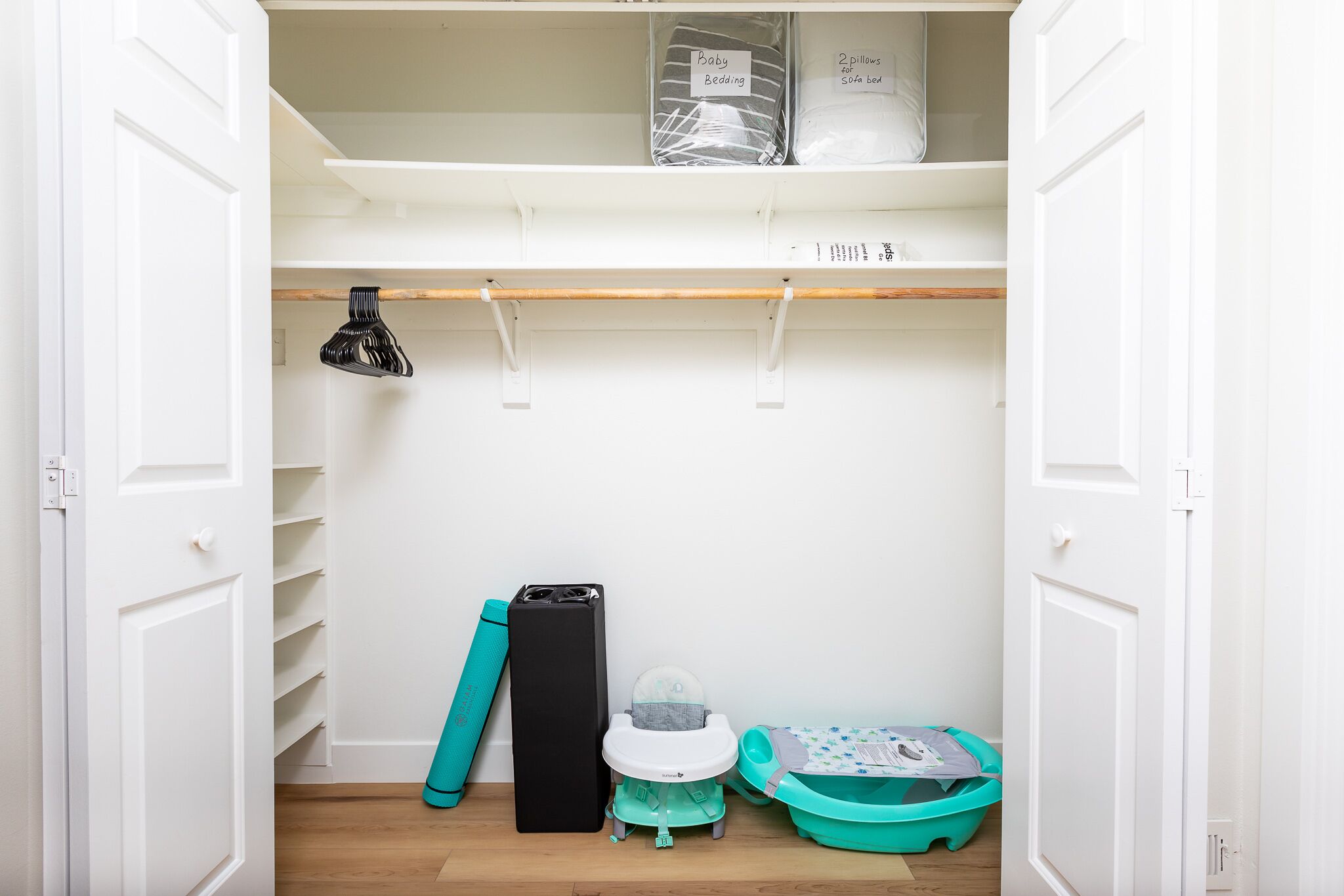 A closet with shelves, a baby changing station, and storage bins.