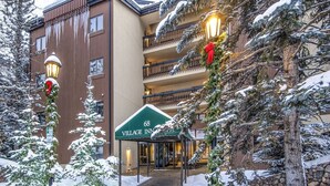 A building with a sign reading "Village Inn" and a brick pathway leading to the entrance. - Village Inn Plaza 103 (Vail)