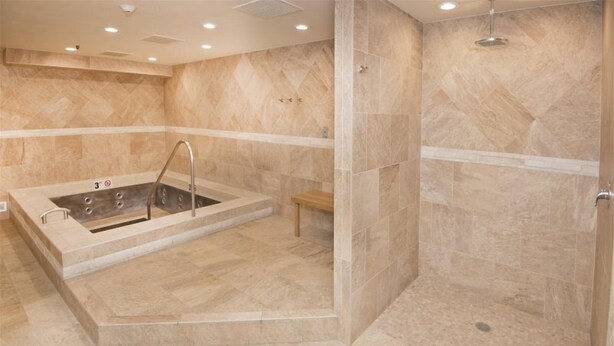 A spa area with a hot tub, a shower, and a bench. - Village Inn Plaza 103 (Vail)