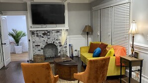 Una sala de estar con chimenea, televisor y sofá.