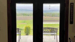 Une porte qui donne sur un espace extérieur aménagé avec un banc et un panneau sur lequel on peut lire « COWBOYS ».