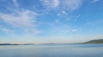 A calm lake with a clear sky and distant hills.