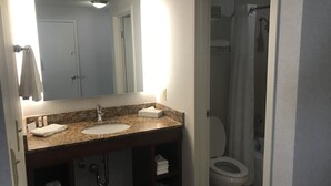 Een badkamer met een wastafel, spiegel en toilet.