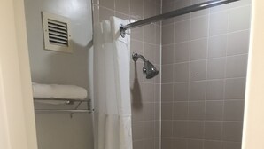 Een badkamer met toilet, douche en bad.