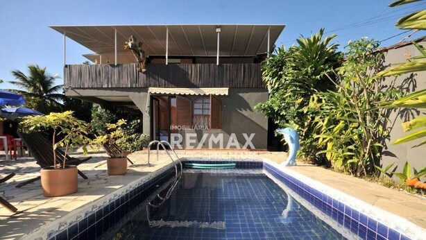 A modern house with a swimming pool, surrounded by potted plants and a clear blue sky. - Pousada Casa da Tatá (Búzios)