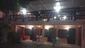 A covered outdoor area with a patio, seating, and a staircase leading to an upper level. - Pousada Casa da Tatá (Búzios)