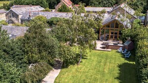 A residential property with a well-maintained lawn, stone steps leading to a house, and a fenced backyard with outdoor seating. - Oakhouse - sleeps 16 guests  in 5 bedrooms (Preston)