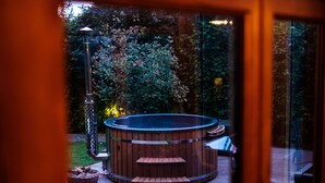A hot tub with wooden steps and a bench, surrounded by a garden with a lamp post and a basket. - Oakhouse - sleeps 16 guests  in 5 bedrooms (Preston)