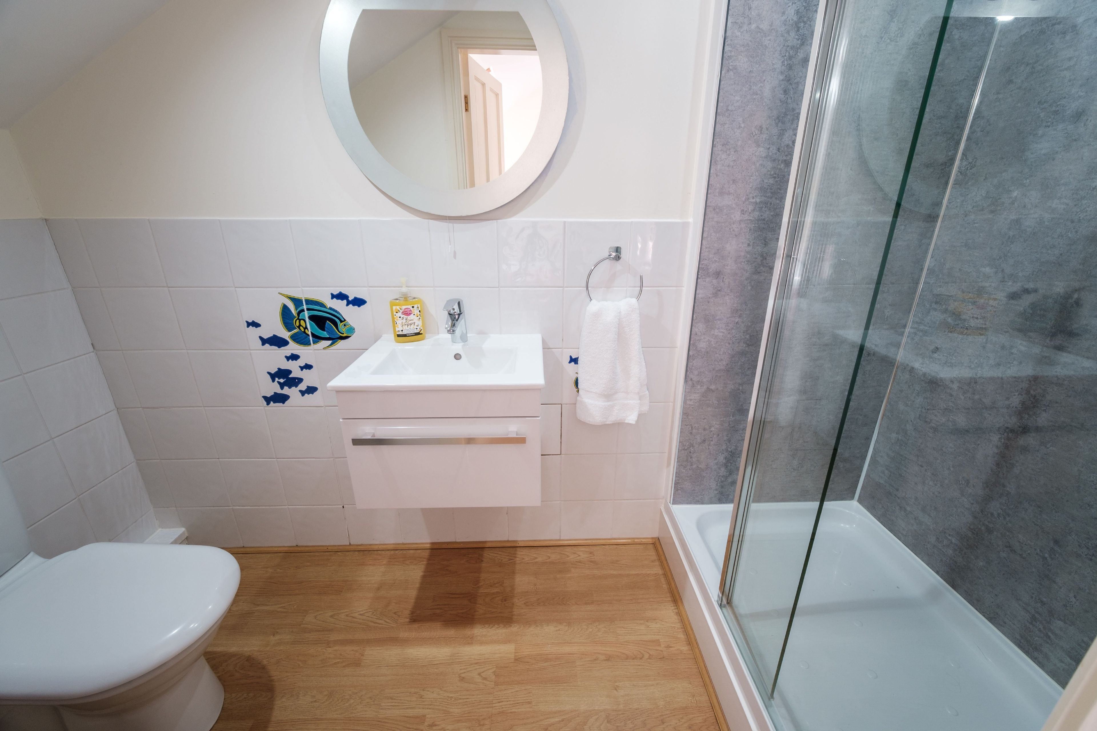 A bathroom with a toilet, sink, and shower.