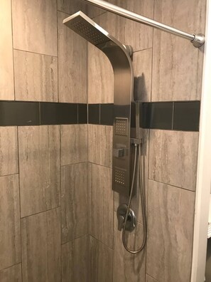 Een douche, handdoeken, zeep, toiletpapier