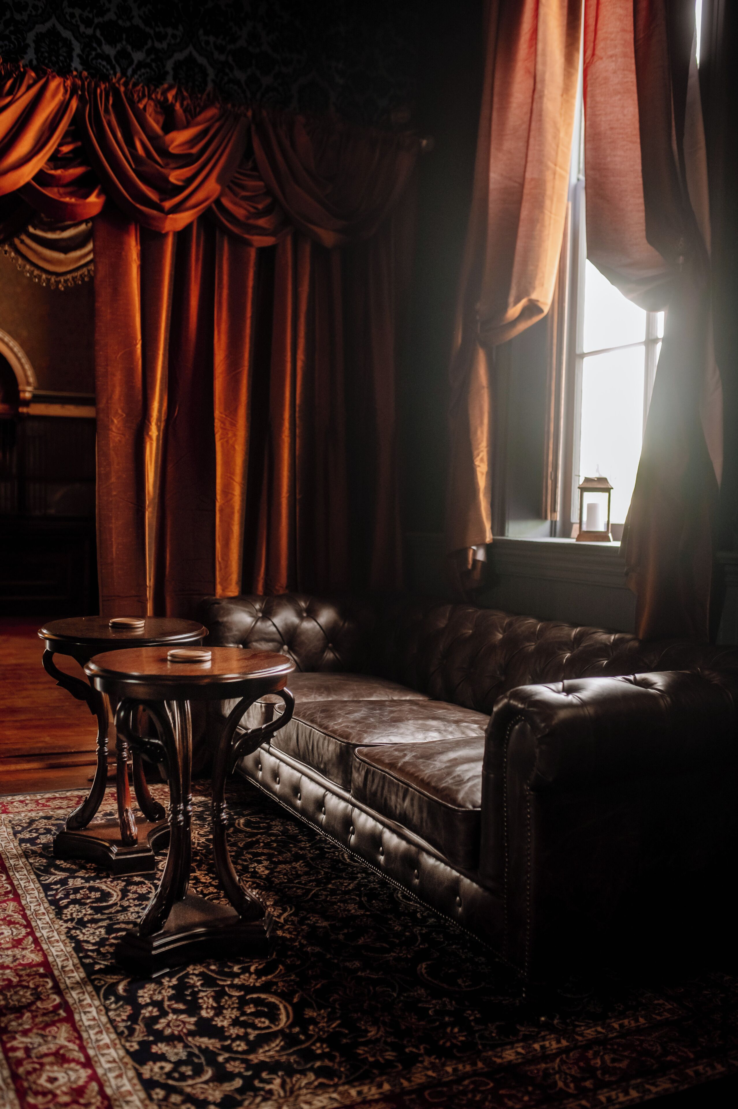 A room with a leather sofa, a small table, and a patterned rug.