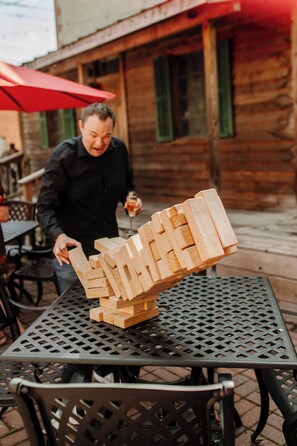 Une personne joue avec des blocs de bois sur une table en métal, à l’extérieur.
