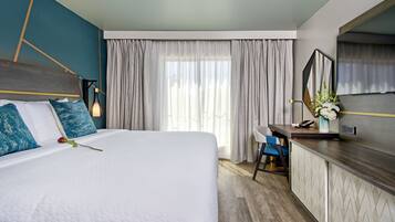Una camera d'albergo moderna con un letto grande, una scrivania e uno specchio.