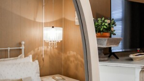 A bedroom with a bed, bedside table, lamp, and a television. - Southern Living for 4 in Richmond Hill (Richmond Hill)