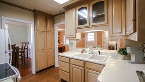 A kitchen with wooden cabinets, a sink, and a countertop. - Southern Living for 4 in Richmond Hill (Richmond Hill)