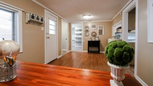 A hallway with wooden flooring, a globe, and a green plant in a white pot. - Southern Living for 4 in Richmond Hill (Richmond Hill)