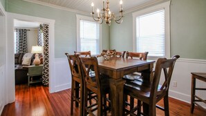 A dining room with a wooden table and chairs, a chandelier, and a view of the living area through a doorway. - Southern Living for 4 in Richmond Hill (Richmond Hill)