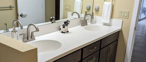 A bathroom with two sinks, a large mirror, and dark wooden cabinets.