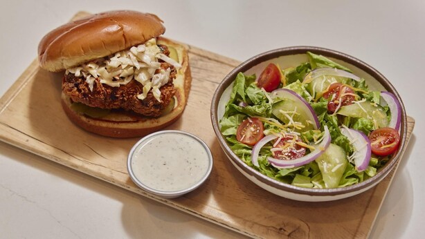 A meal consisting of a burger with coleslaw and a side salad with tomatoes, onions, and shredded cheese. - Hyatt Place Houston Medical Center (Houston)